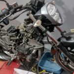 Motocicleta totalmente desarmada mostrando solo el chasis en mantenimiento en Motocyclón